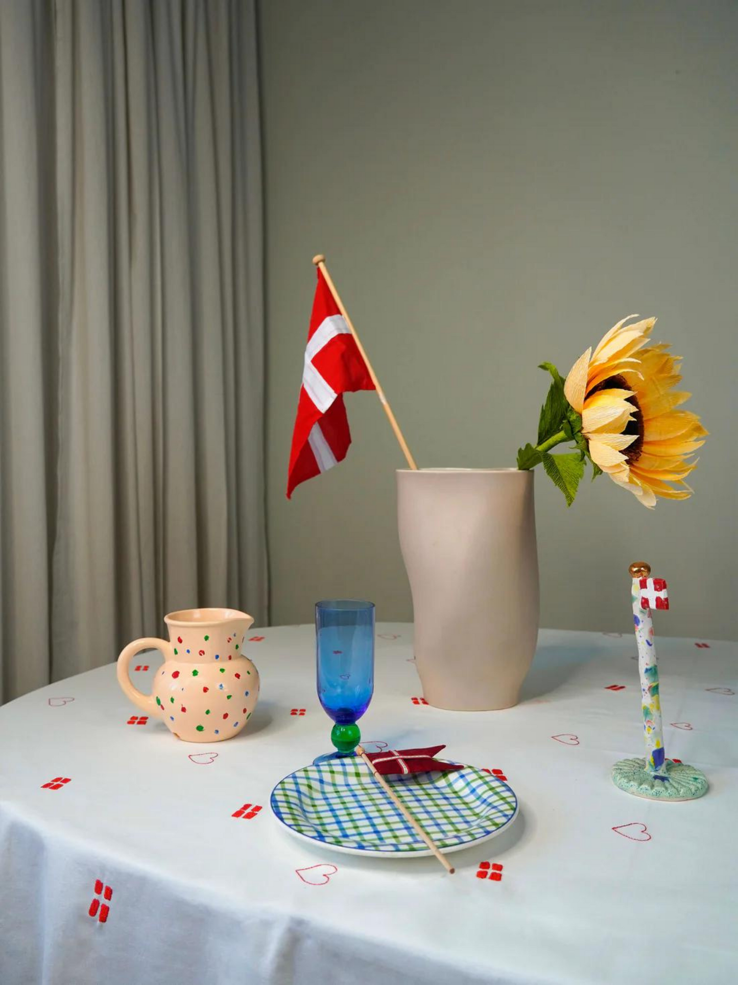 Hvid dug med broderet røde flag og røde hjerter