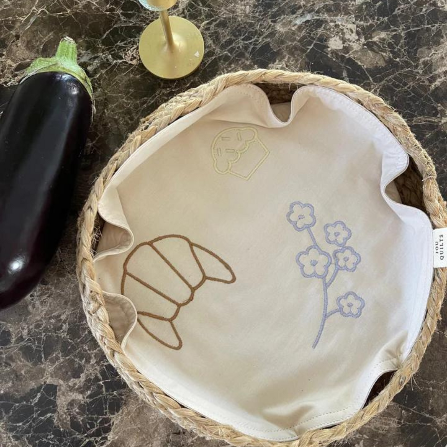 Servietten har en broderede croissant, muffin og en blomsterstilk